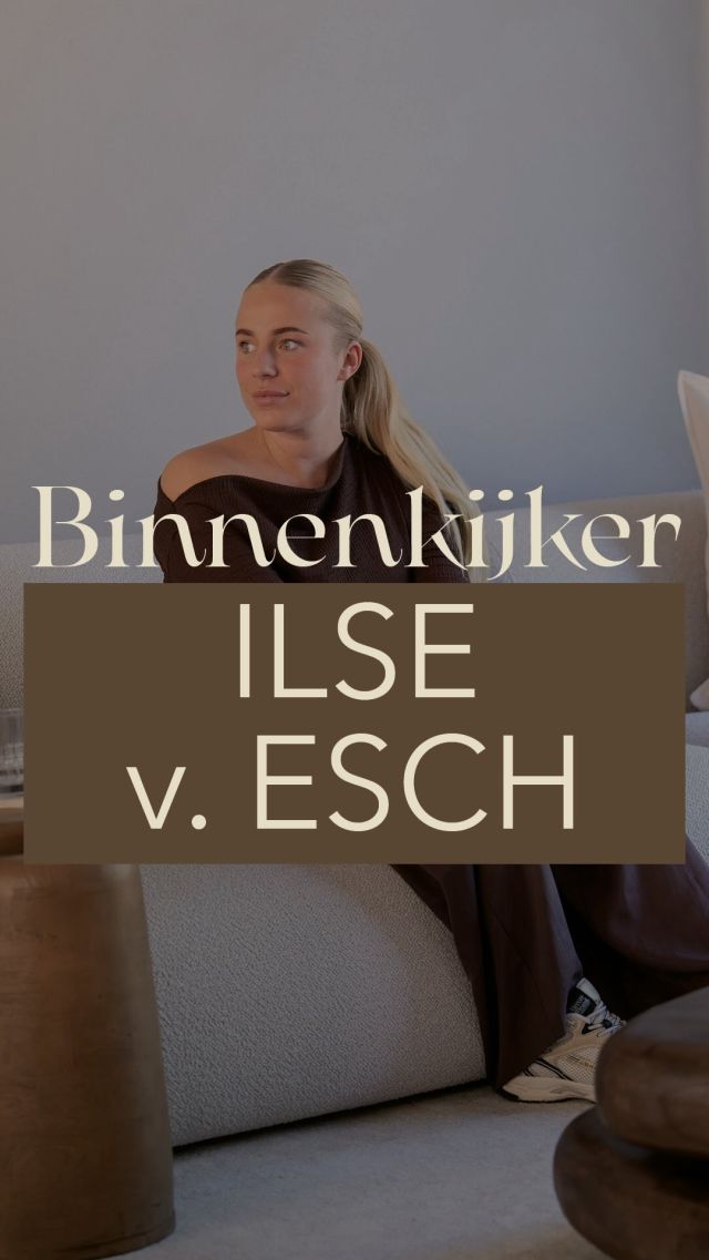Warme living met lagen textiel, plaid en zacht avondlicht